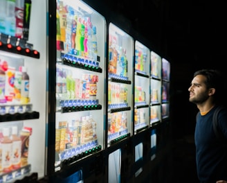 man on front of vending machines at nighttime