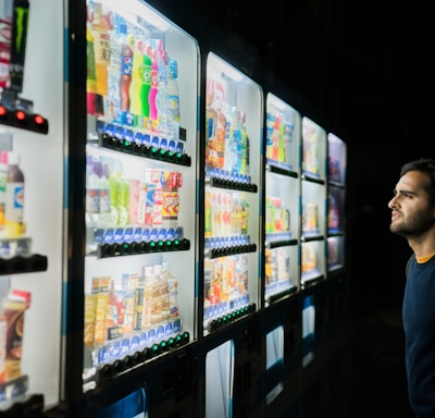 man on front of vending machines at nighttime