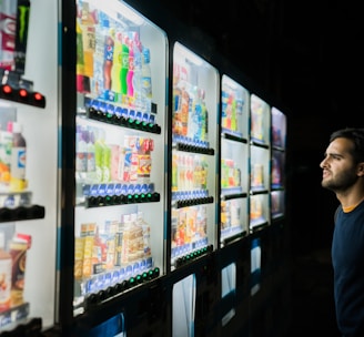 man on front of vending machines at nighttime