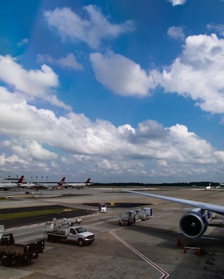 Ground service equipment lined up at a busy airport runway.