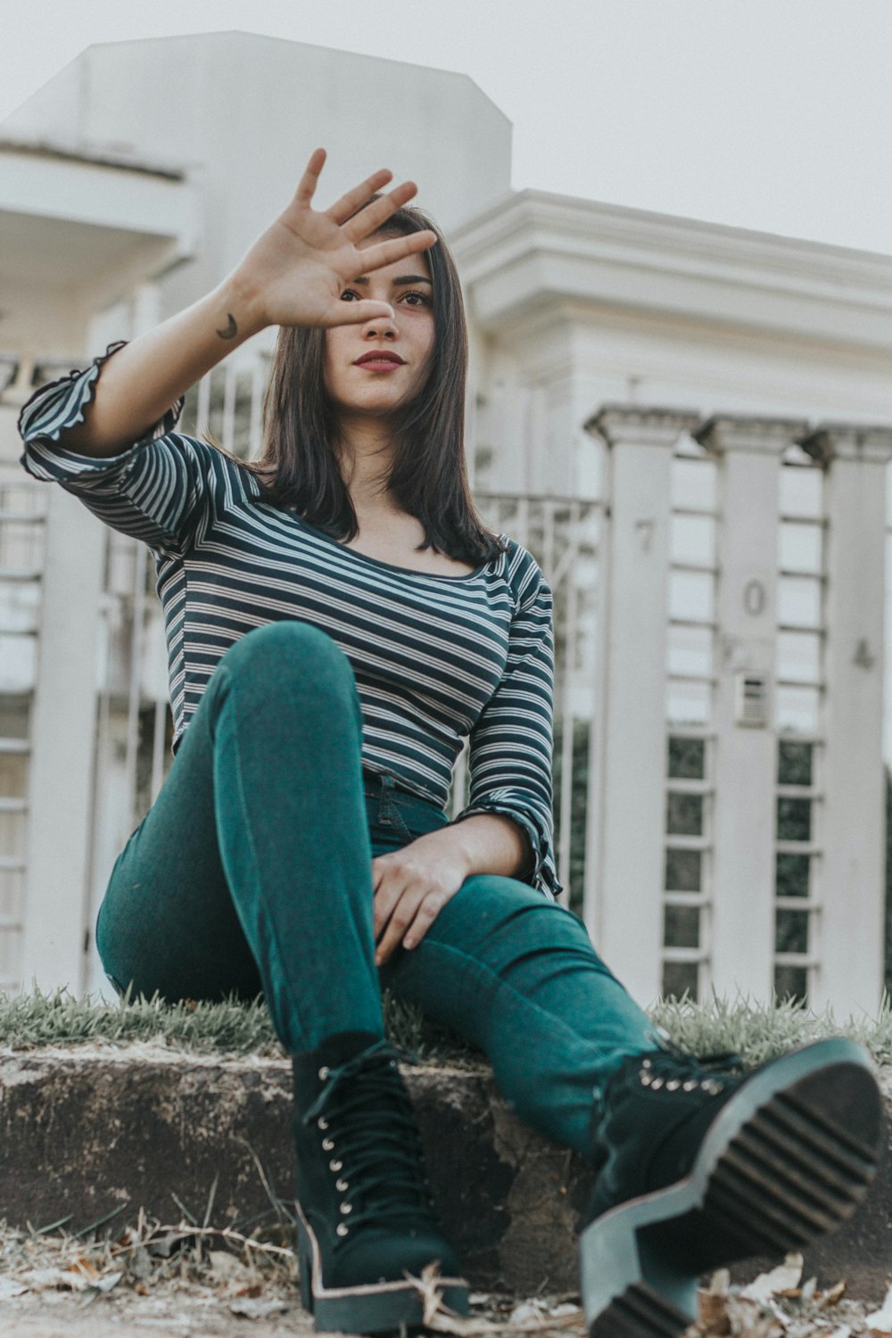 woman sitting on ground while covering her face