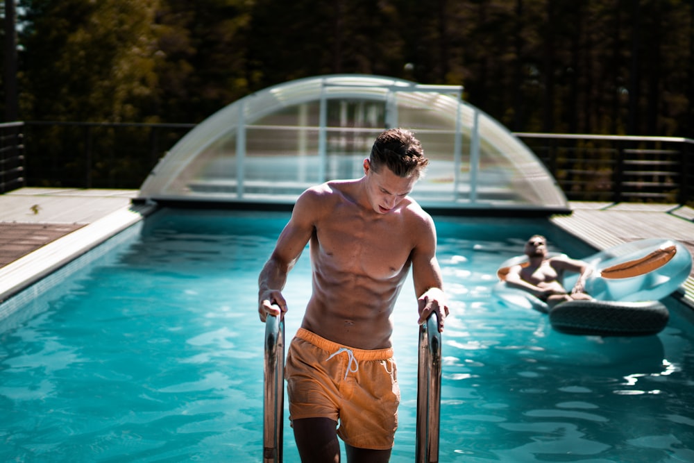 hombre sosteniendo escalera de piscina de acero gris