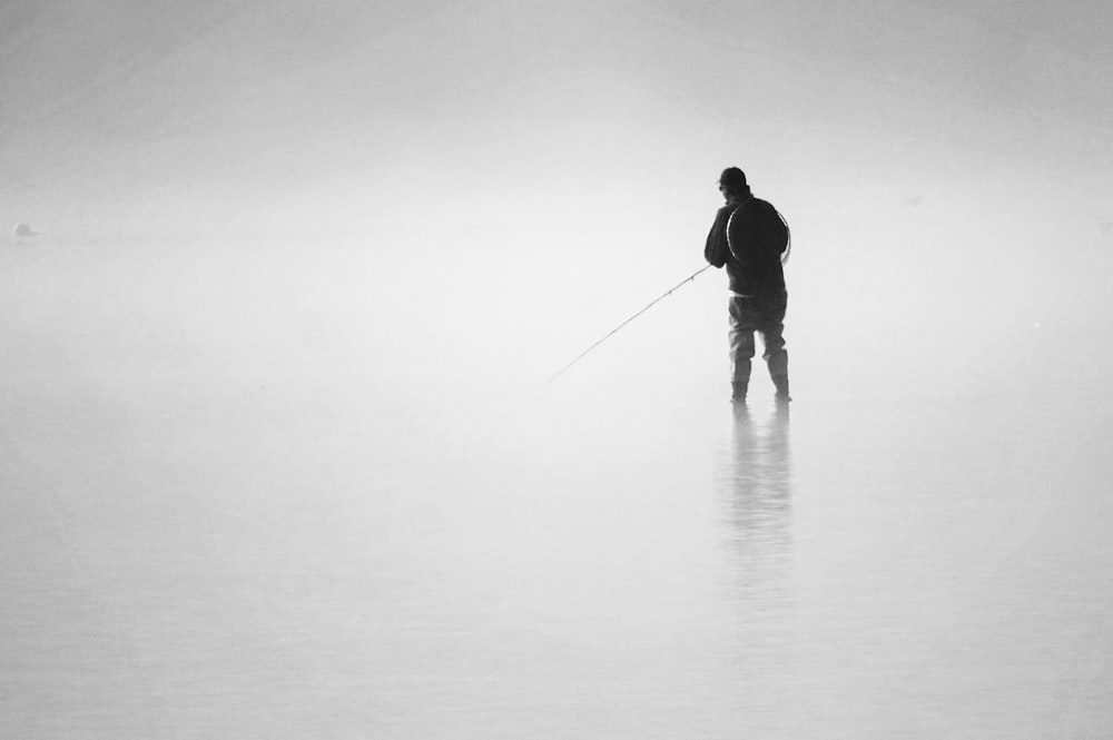 Photo en niveaux de gris d’un homme sur un plan d’eau