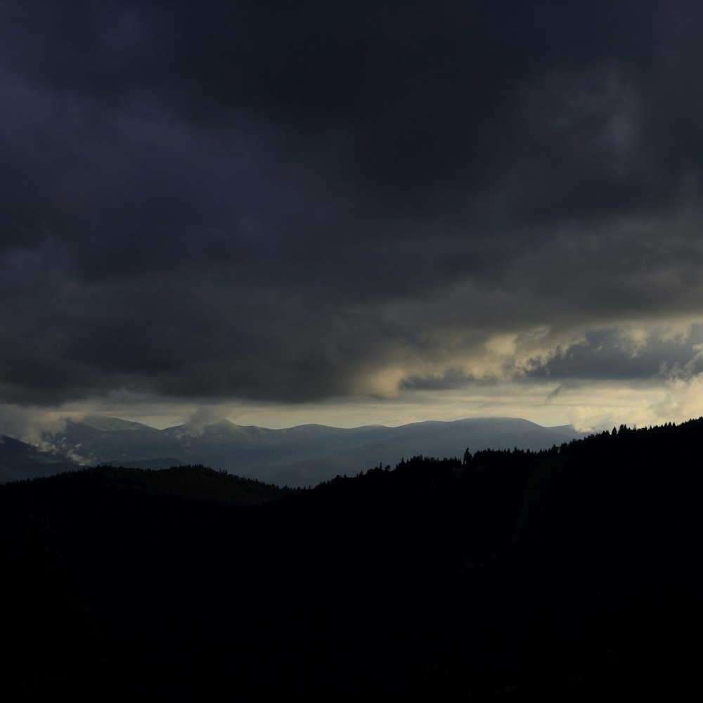 silhouette of mountain under gloomy sky