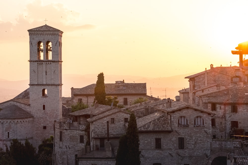 gray concrete houses and tower during golden hour