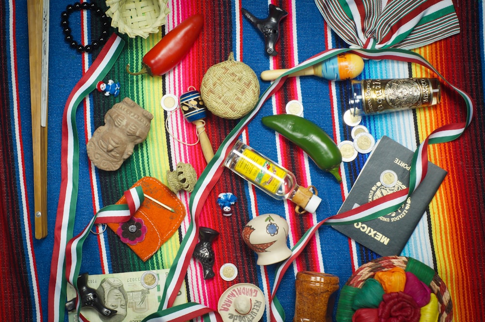 flat lay photography of vial, medal, and book on striped cloth