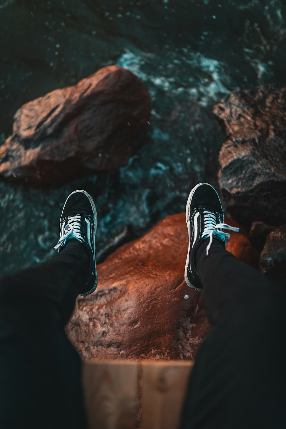 high-angle of person sitting on cliff