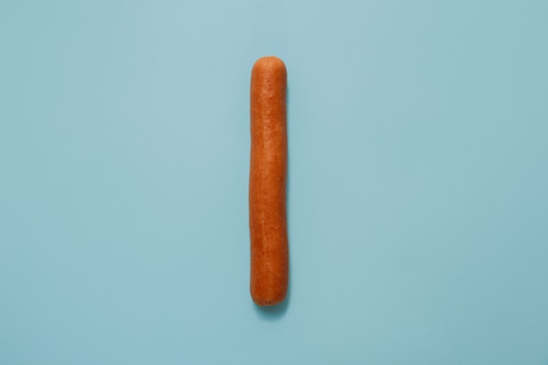 Simple, clean image of a single smoked sausage on a white background