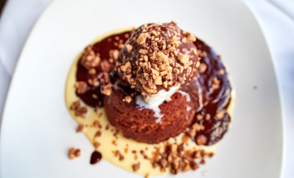 chocolate ice cream with peanut sprinkles on white plate