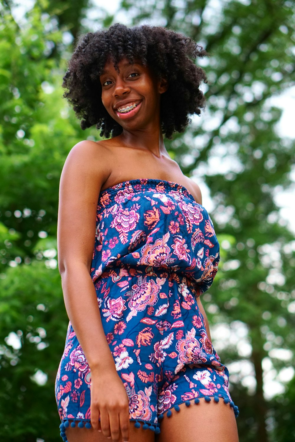 selective focus photography woman wearing blue and pink floral tube rompers