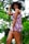 A satisfied customer showcasing her new outfit in a floral garden.