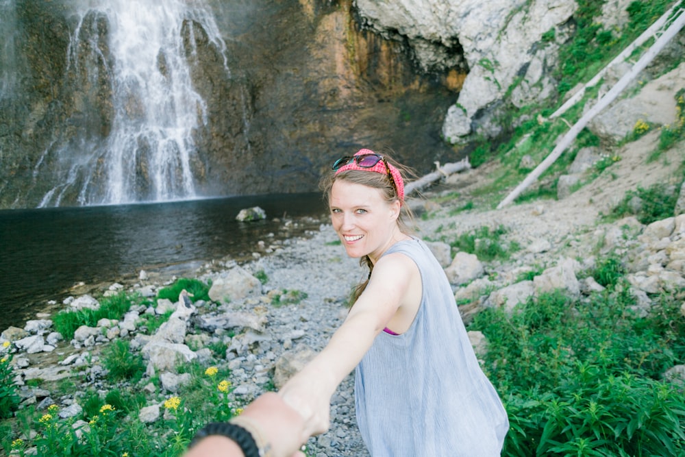 woman standing far away from waterfall