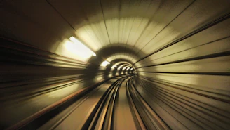 A futuristic spaceship zooming through a neon-lit space tunnel with stars streaking past.