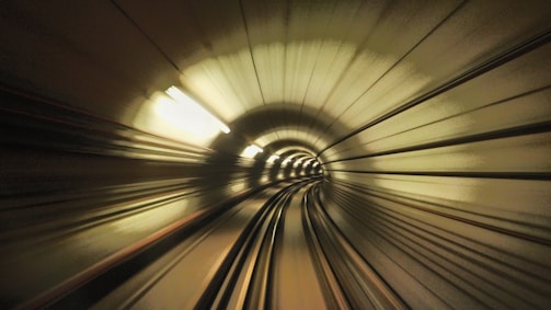 High-speed view inside a futuristic tunnel with curved walls and motion blur effect, giving a sense of fast movement and depth.