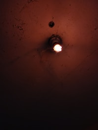 Dimly lit room showing a flickering light bulb and a worried homeowner.