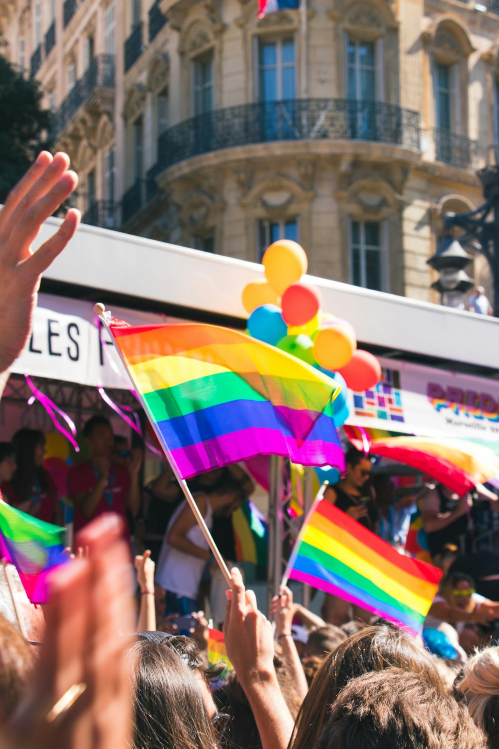 people holding yellow, green, blue, and purple flag