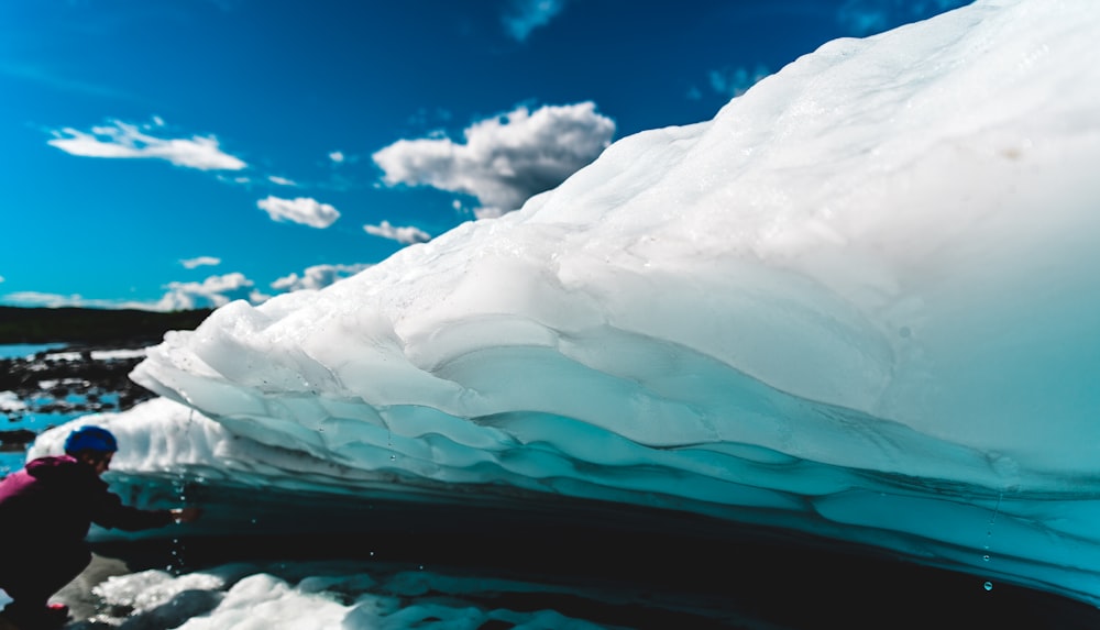 Hombre sentado cerca de un iceberg