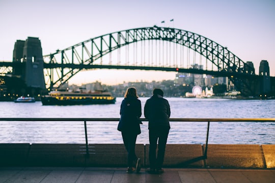 man and woman standing beside each other in front of body of water in Sydney Harbour Bridge Australia