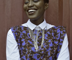 woman smiling beside red wall