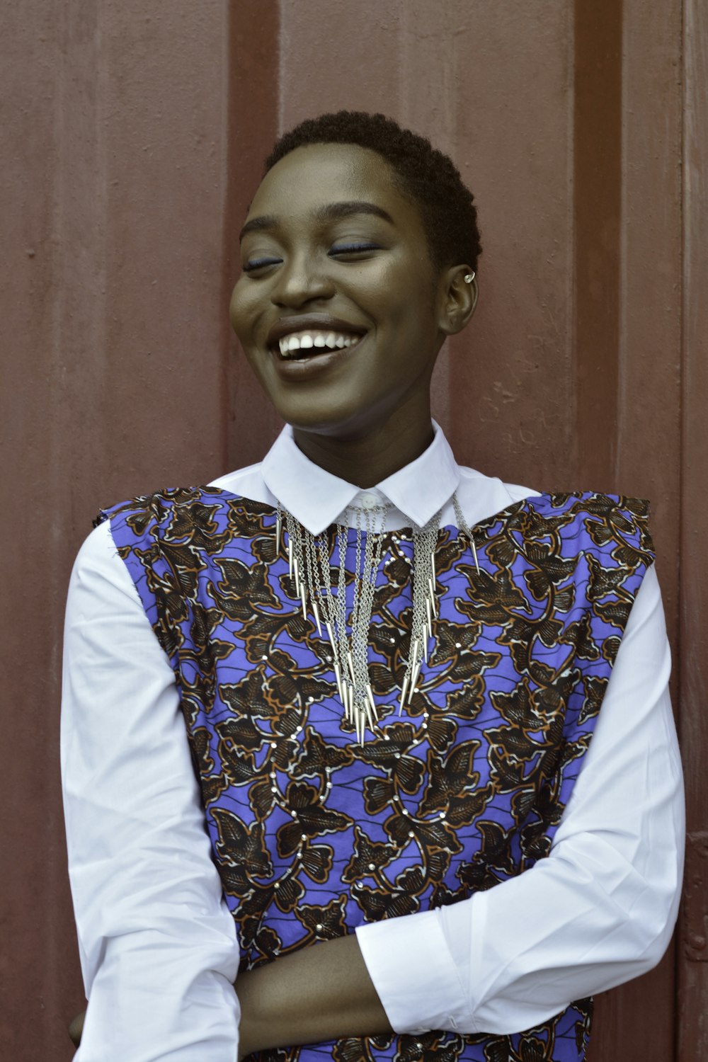 mulher sorrindo ao lado da parede vermelha