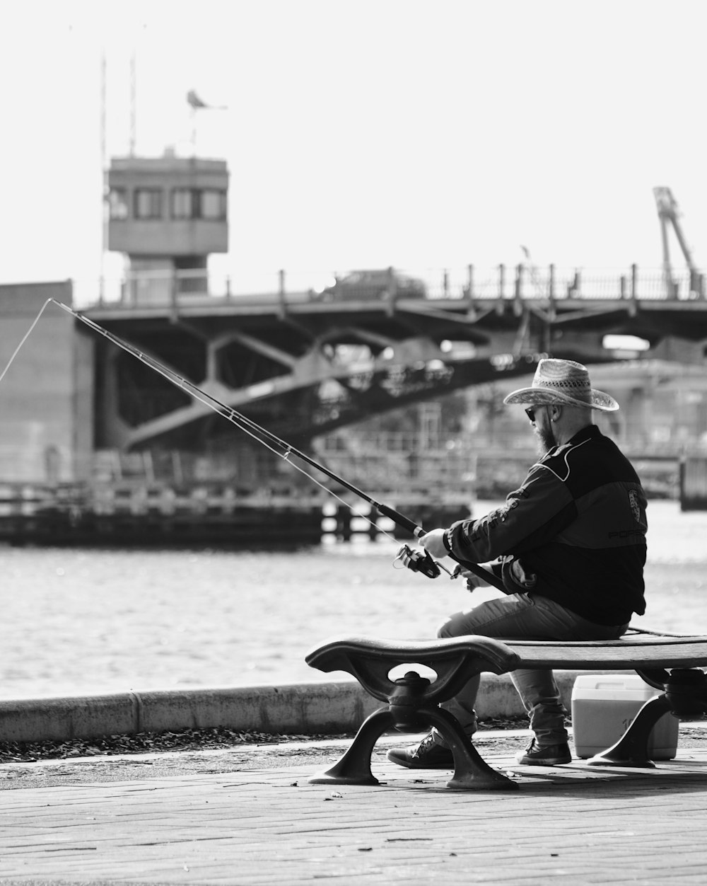 grayscale photo of a man while fishing