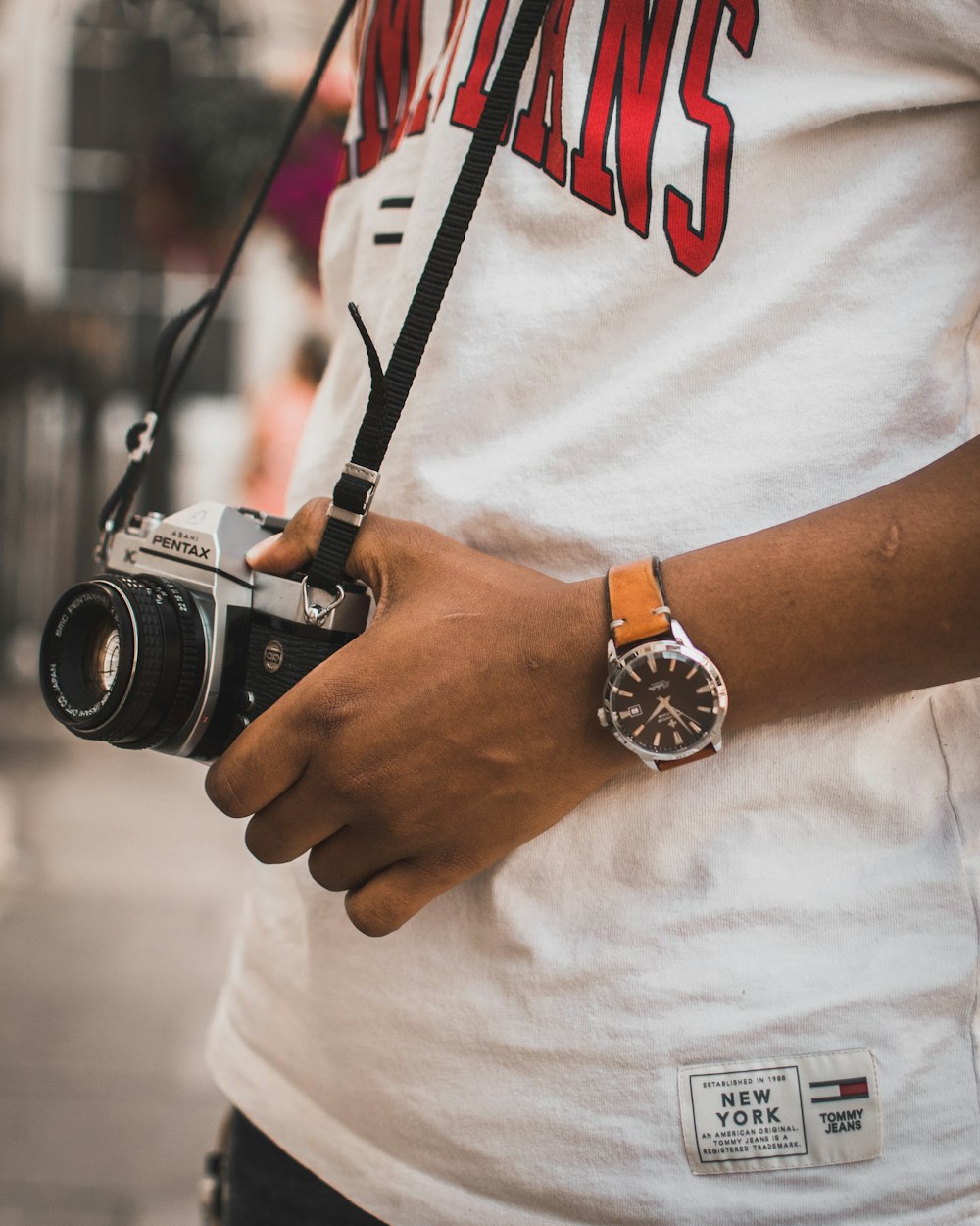 person carrying black and silver Pentax camera