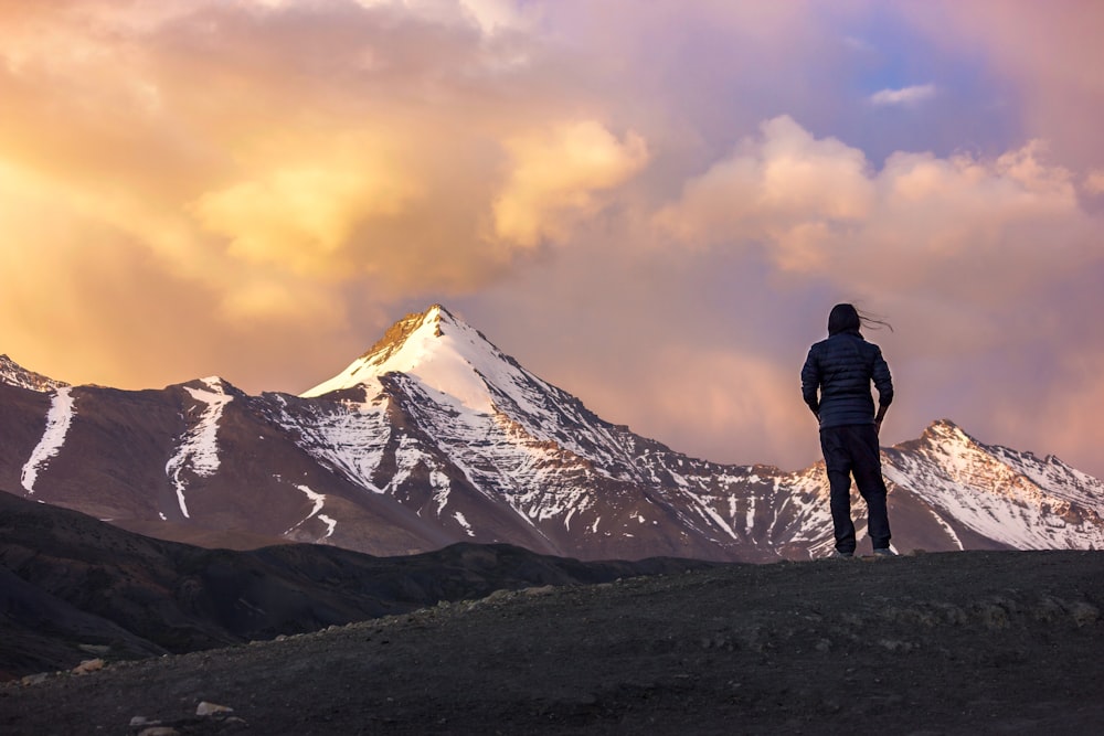 person at the top of mountain facing another mountain