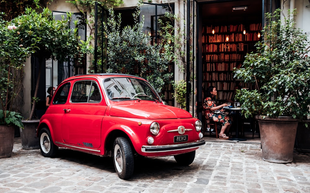 red 3-door hatchback parked outside establishment