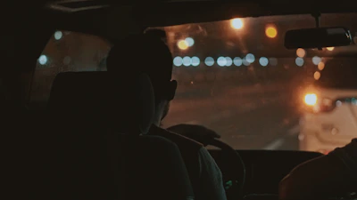 A close-up of a driver checking the vehicle before a night run, highlighting dedication to safety.