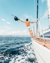 man wearing white shorts on a sail ship ascendedviews.com branding marketing videography drone shot