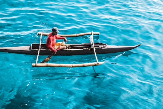 man riding row boat on sea in Cebu City Philippines