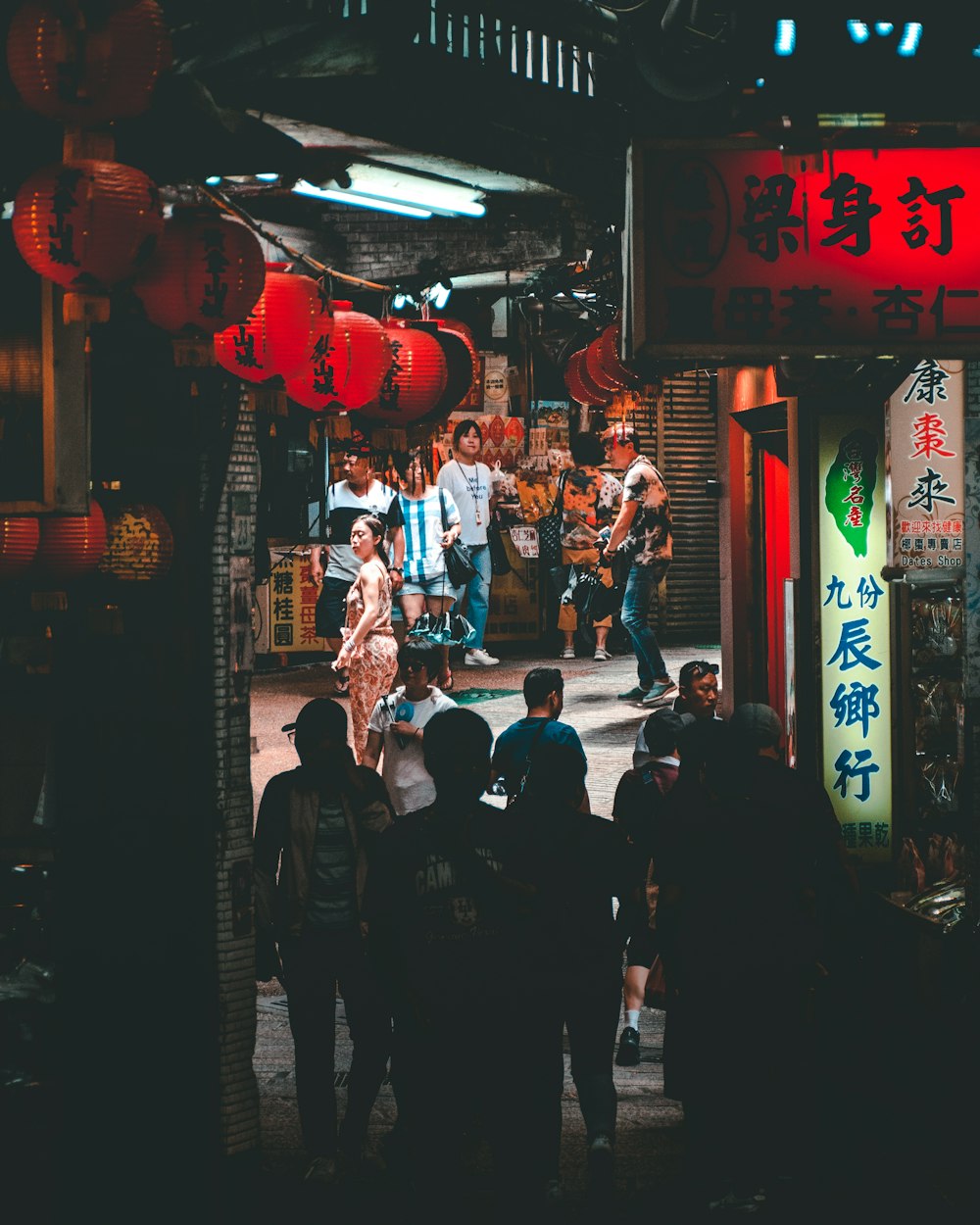 people walking on pathway between stores