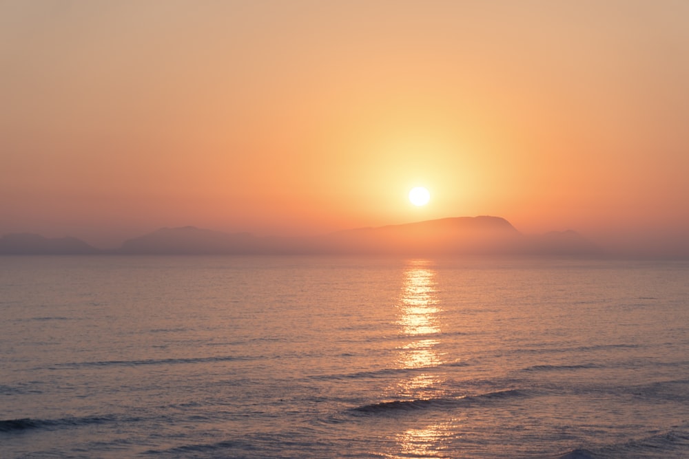 calm sea under clear blue sky during sunset