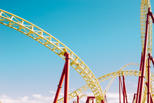 yellow and red roller coaster under blue sky at daytime in Sochi Russia
