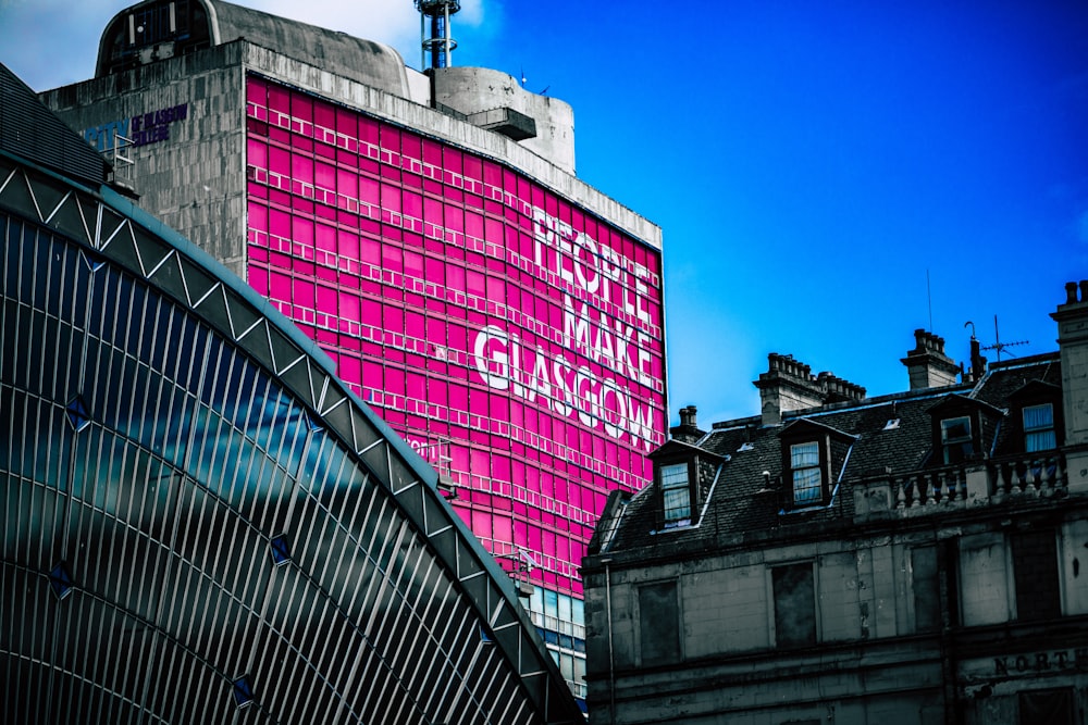 Flachwinkelansicht des Gebäudes mit Menschen machen Glasgower Werbetafel