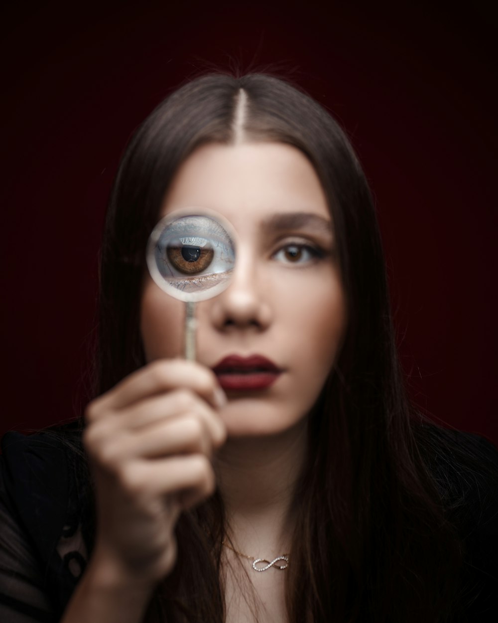 woman looking through magnifying glass