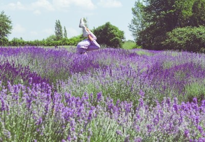 An artistic shot of a gymnast performing in a lavender field.