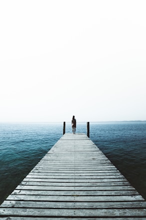 woman standing on water dock