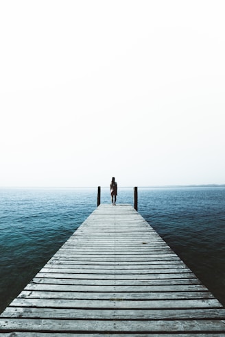 woman standing on water dock