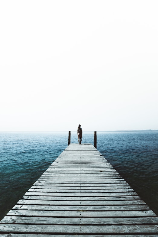 woman standing on water dock