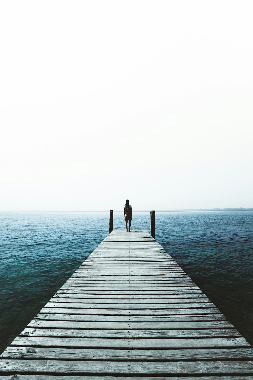 woman standing on water dock