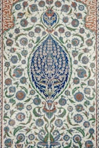 an intricately designed rug with blue and green flowers