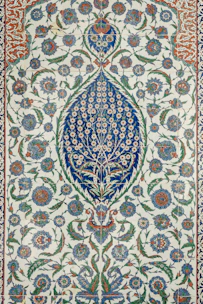 an intricately designed rug with blue and green flowers