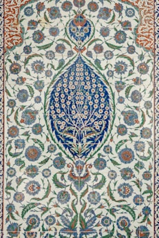 an intricately designed rug with blue and green flowers