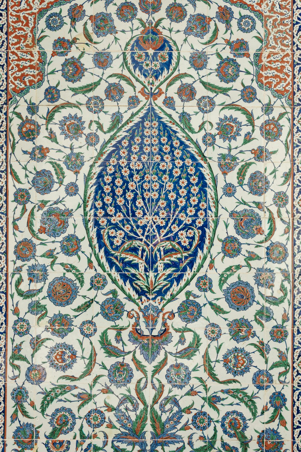 Un tapis au design complexe avec des fleurs bleues et vertes