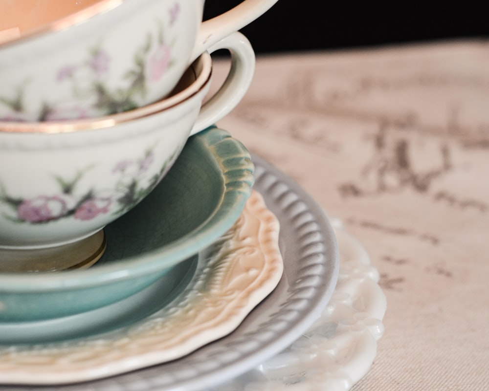 청록색과 흰색 세라믹 그릇과 컵의 얕은 초점 사진