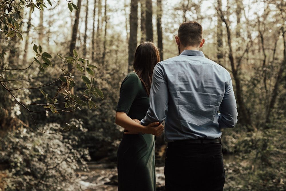 man and woman standing inside forest