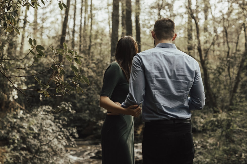 man and woman standing inside forest