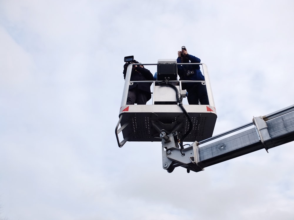 two person standing on cherry picker trailer