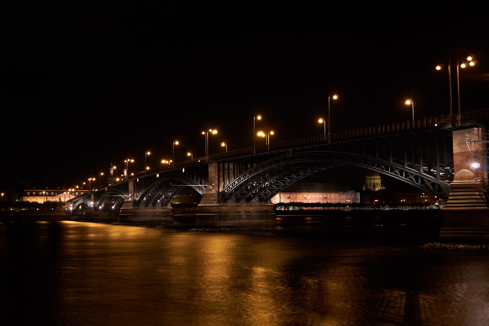 lighted metal arch bridge at night